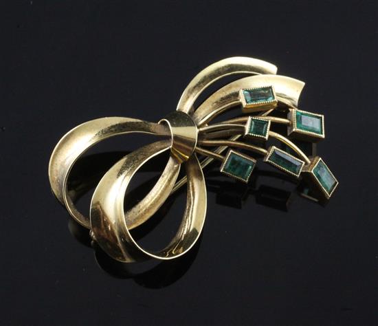 A Venezuelan 18ct gold and emerald ribbon bow spray brooch, signed Bauer, 40mm.